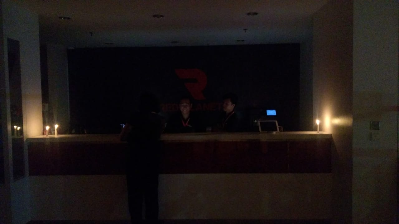 Staff hotel bagian Front Office menggunakan cahaya lilin
